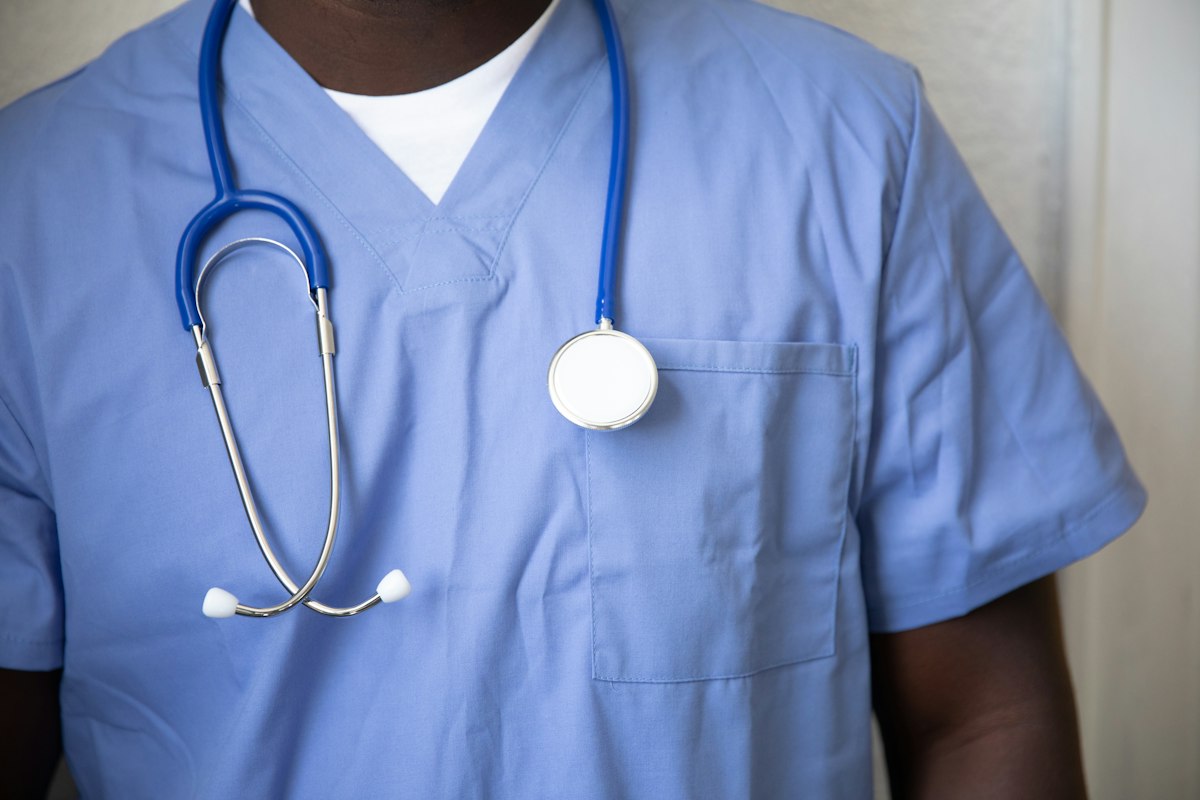 A health worker in scrubs with a stethoscope